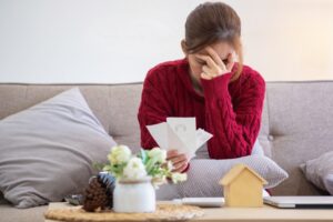 A worker reviews overdue bills after not being paid on time by an employer in Massachusetts.